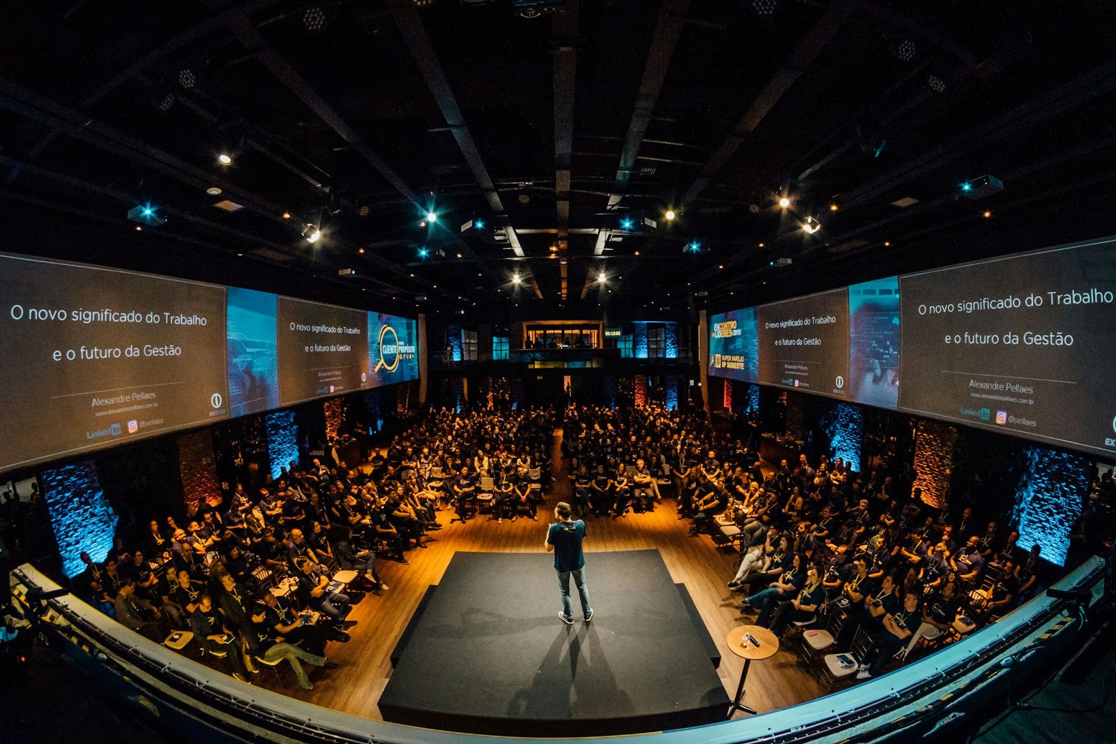 Speaker on stage addressing a large conference audience